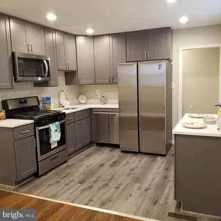 a kitchen with stainless steel appliances granite countertop a sink a stove a refrigerator and cabinets