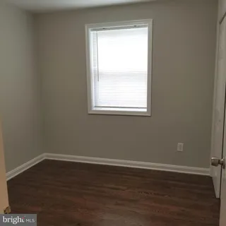 an empty room with wooden floor and a window