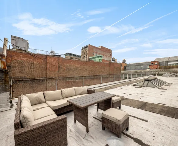 a view of roof deck with couches and sky view