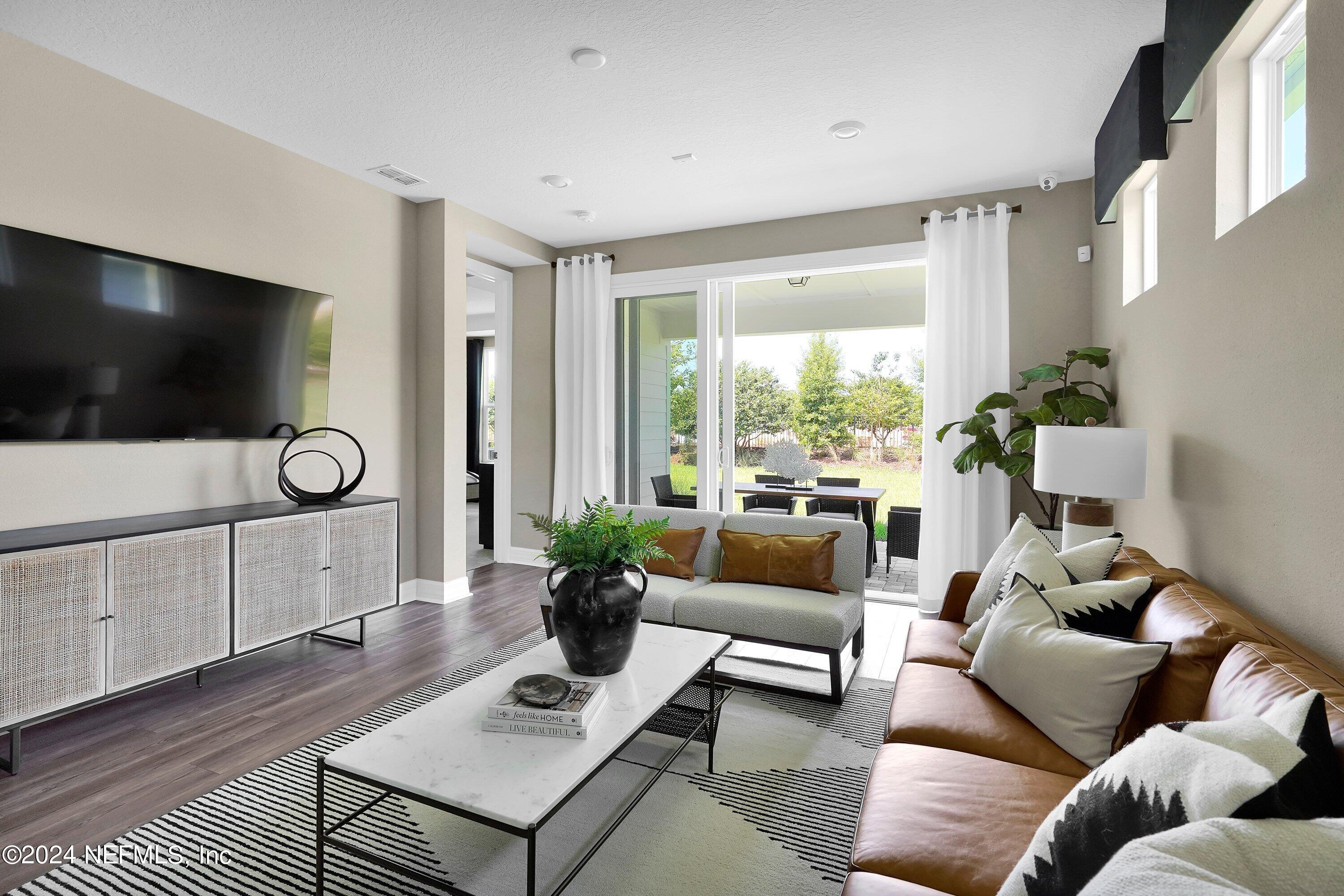 507 Goodwill Court Yulee, FL 32097 - Photo 6 of 38 a living room with furniture a flat screen tv and a large window