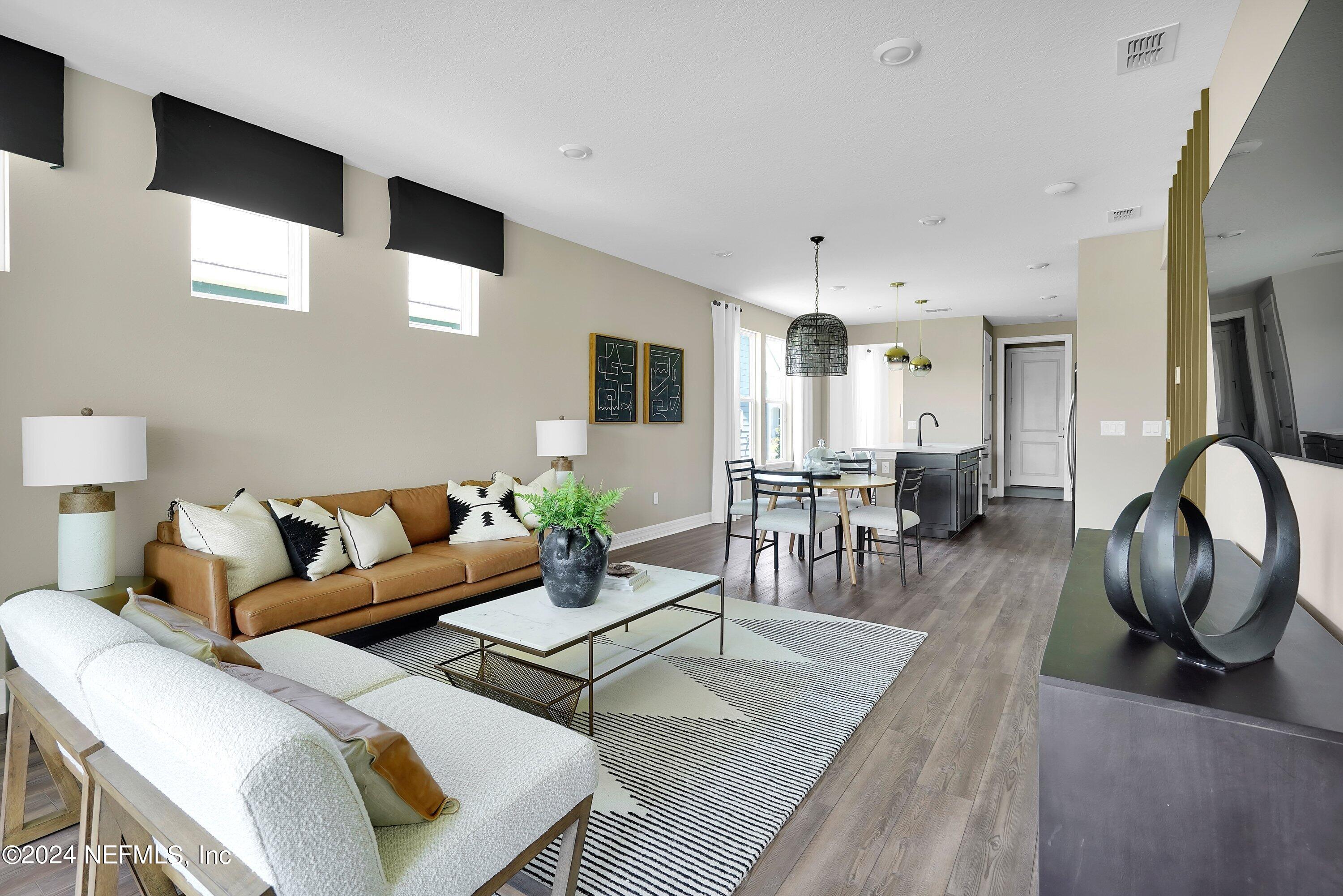 507 Goodwill Court Yulee, FL 32097 - Photo 8 of 38 a living room with furniture a flat screen tv and kitchen view