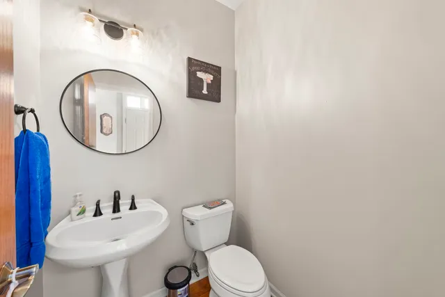 a bathroom with a toilet a sink and a mirror
