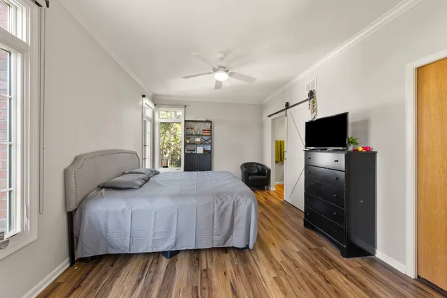 a bedroom with a bed and a flat tv screen on dresser