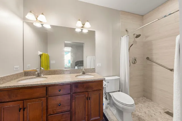 a bathroom with a double vanity sink toilet and shower
