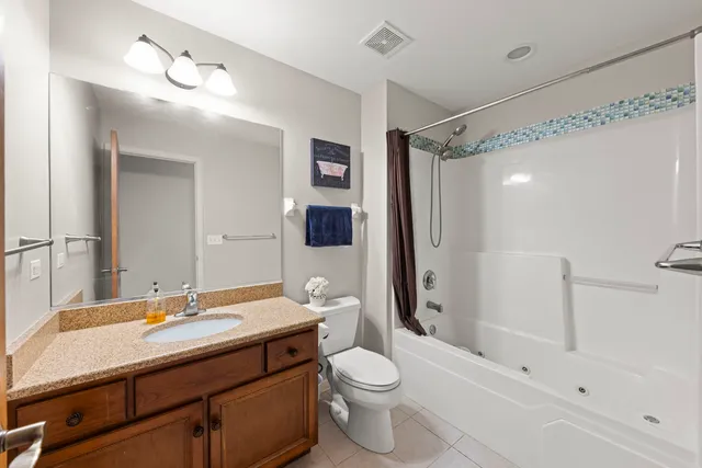 a bathroom with a sink a toilet a mirror a bathtub and shower