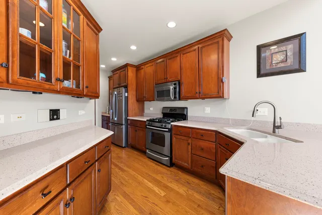 a kitchen with stainless steel appliances granite countertop a sink stove and refrigerator