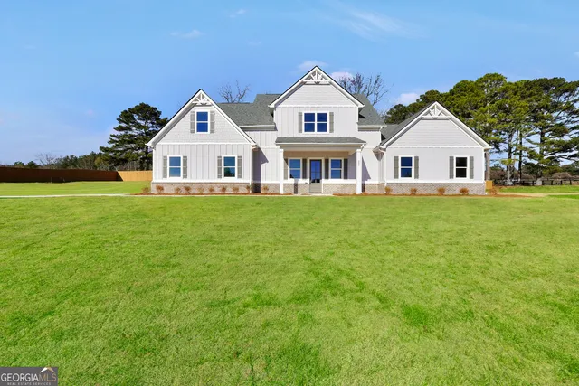 a view of a house with a big yard and large trees