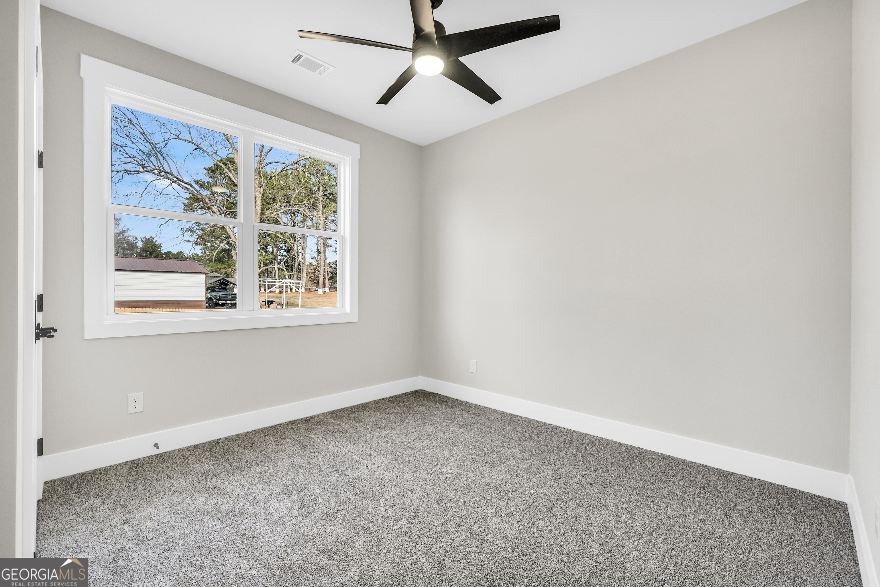 297 East Knight Road McDonough, GA 30252 - Photo 43 of 64 an empty room with a window and a fan