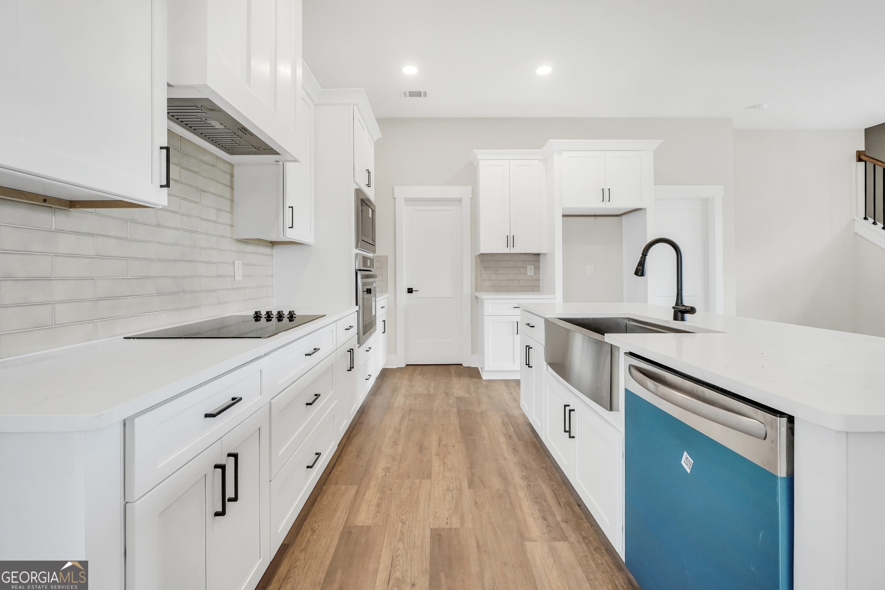 297 East Knight Road McDonough, GA 30252 - Photo 9 of 64 a large kitchen with stainless steel appliances sink a stove and white cabinets with wooden floor