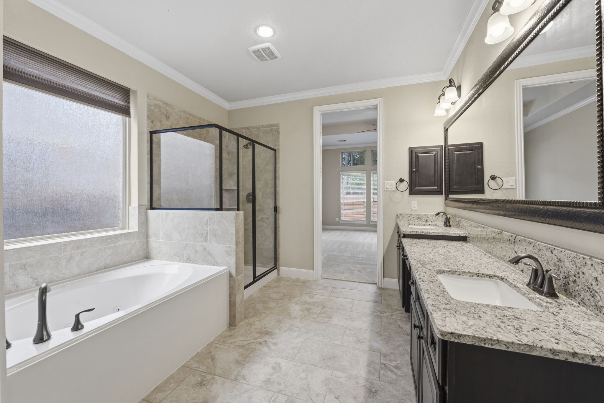 25210 Gaddis Oaks Drive Spring, TX 77389 - Photo 19 of 50 a bathroom with a granite countertop tub sink and mirror