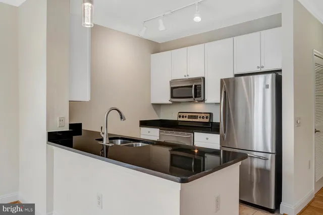 a kitchen with granite countertop a refrigerator and a sink