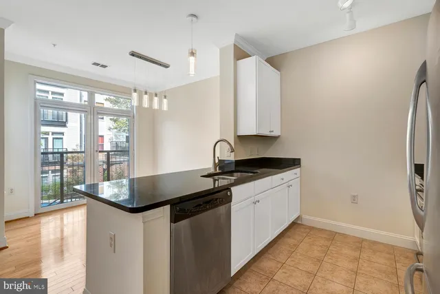 a kitchen with granite countertop a sink and a refrigerator