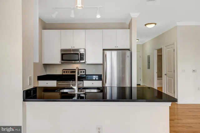 a kitchen with stainless steel appliances a refrigerator and a stove top oven