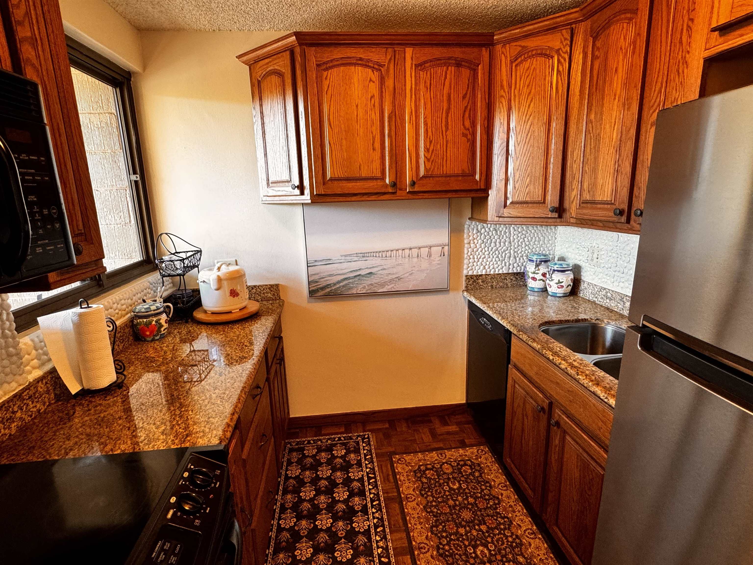 4310 Lower Honoapiilani Road, Unit 315 Lahaina, HI 96761 - Photo 3 of 20 a kitchen with stainless steel appliances granite countertop a refrigerator and a stove top oven