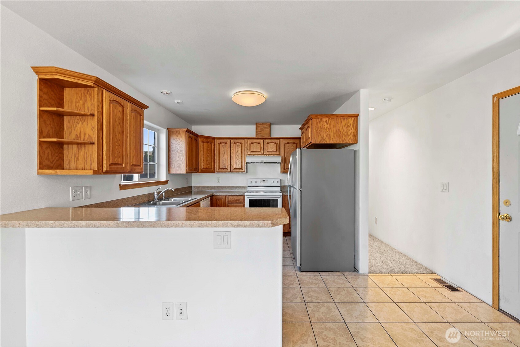 203 Marr Street Wenatchee, WA 98801 - Photo 5 of 22 a kitchen with a sink a refrigerator and window