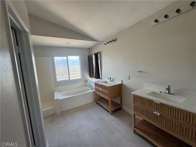 a bathroom with 2 sink tub and a mirror