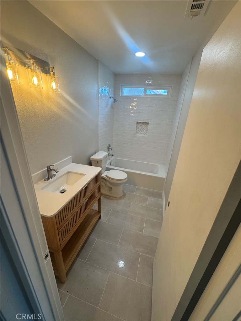 1988 West Sunnyview Drive Rialto, CA 92377 - Photo 2 of 2 a bathroom with a sink a toilet a mirror and a window
