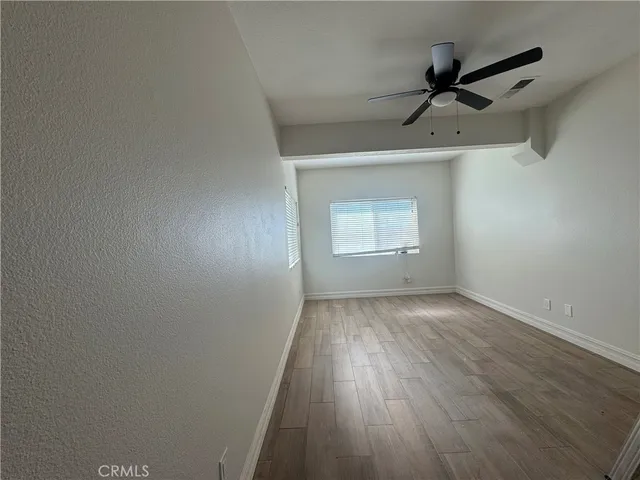 a view of a room with wooden floor closet and windows