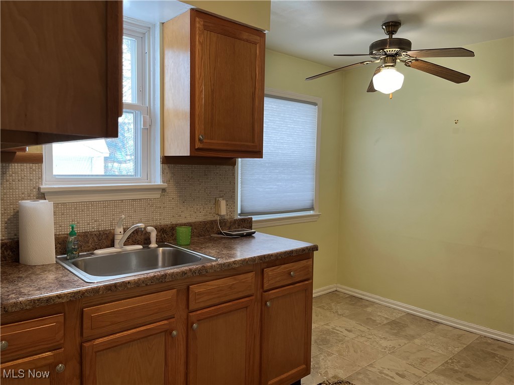 15405 Corkhill Road Maple Heights, OH 44137 - Photo 5 of 50 Kitchen featuring ceiling fan, a healthy amount of sunlight, backsplash, and sink