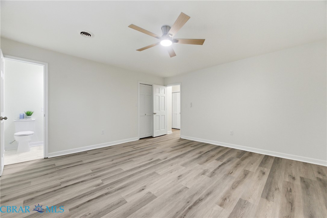 718 Dandy Loop Road Yorktown, VA 23692 - Photo 13 of 42 Unfurnished bedroom with light wood-type flooring, a ceiling fan, ensuite bath, and a closet
