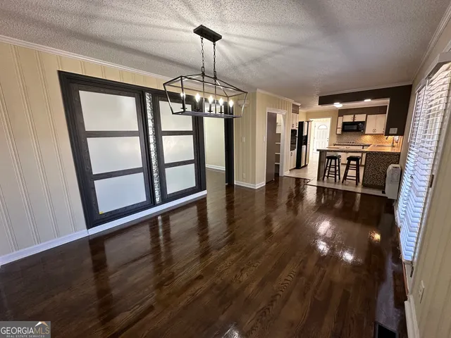 an empty room with wooden floor ceiling fan and windows
