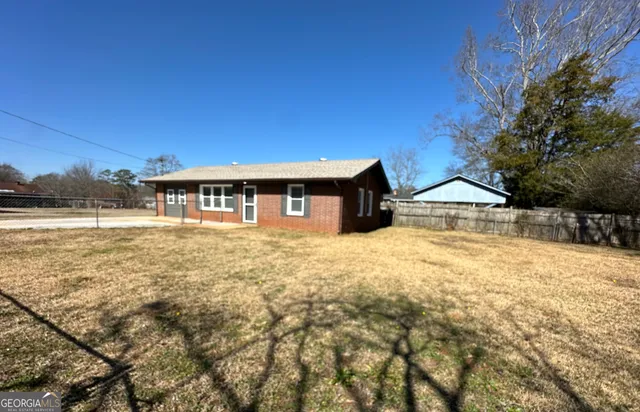 a kitchen with stainless steel appliances granite countertop a stove top oven a sink dishwasher a dining table and chairs with wooden floor