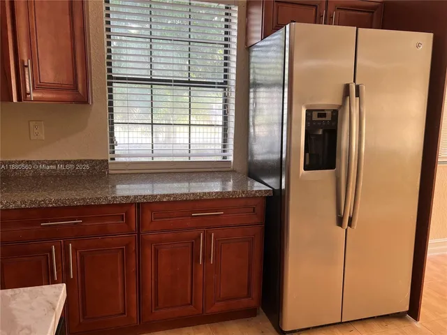 a kitchen with stainless steel appliances granite countertop a refrigerator and a sink