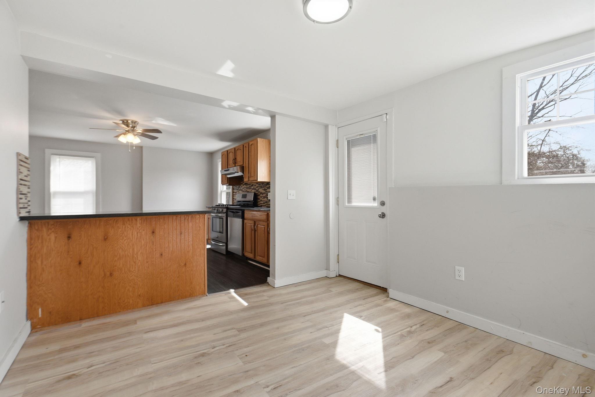 97 Maple Street Newburgh, NY 12550 - Photo 15 of 31 Kitchen with dark countertops, backsplash, light wood-style floors, and wood finish cabinetry