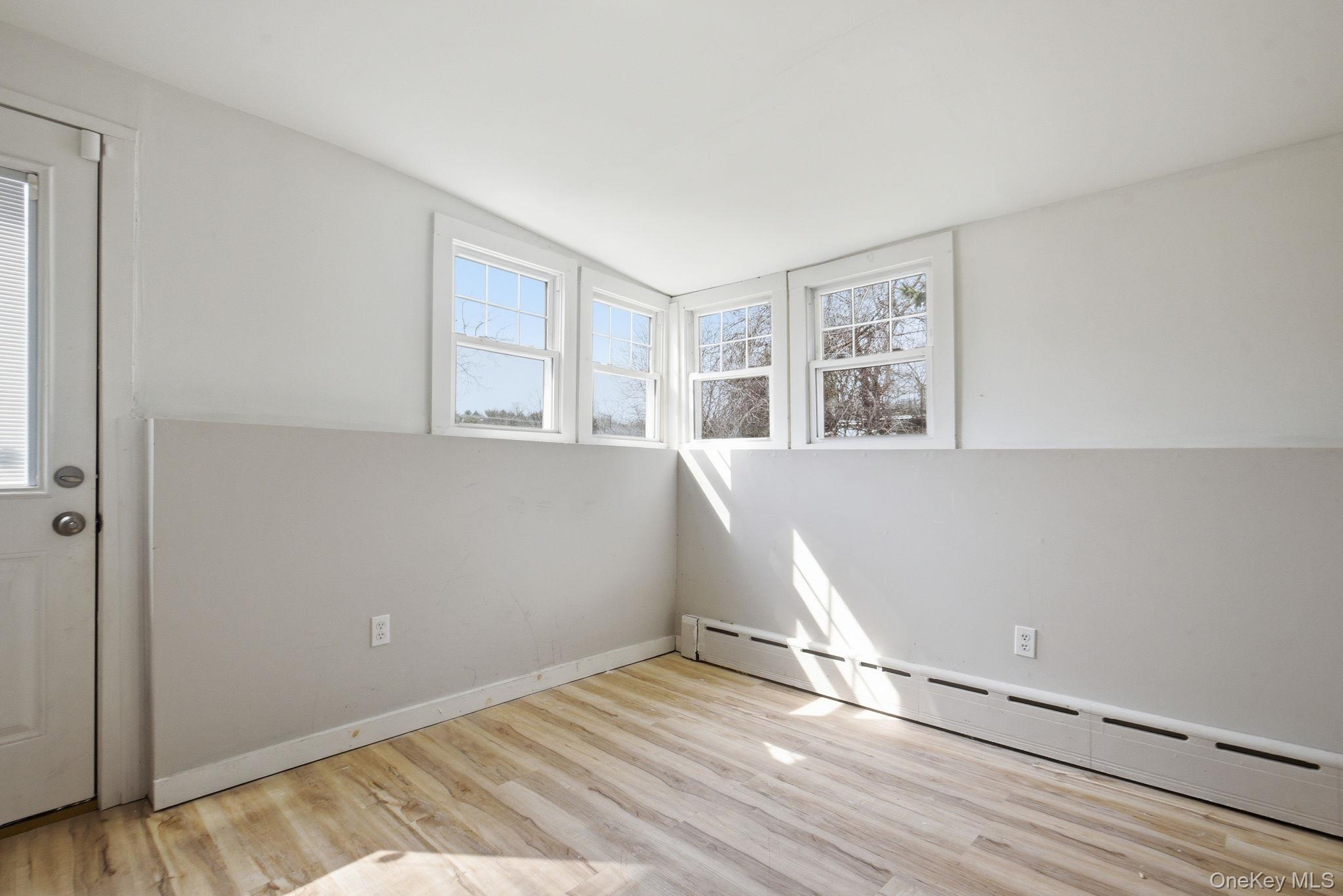 97 Maple Street Newburgh, NY 12550 - Photo 17 of 31 Spare room featuring a baseboard radiator and light wood-style floors