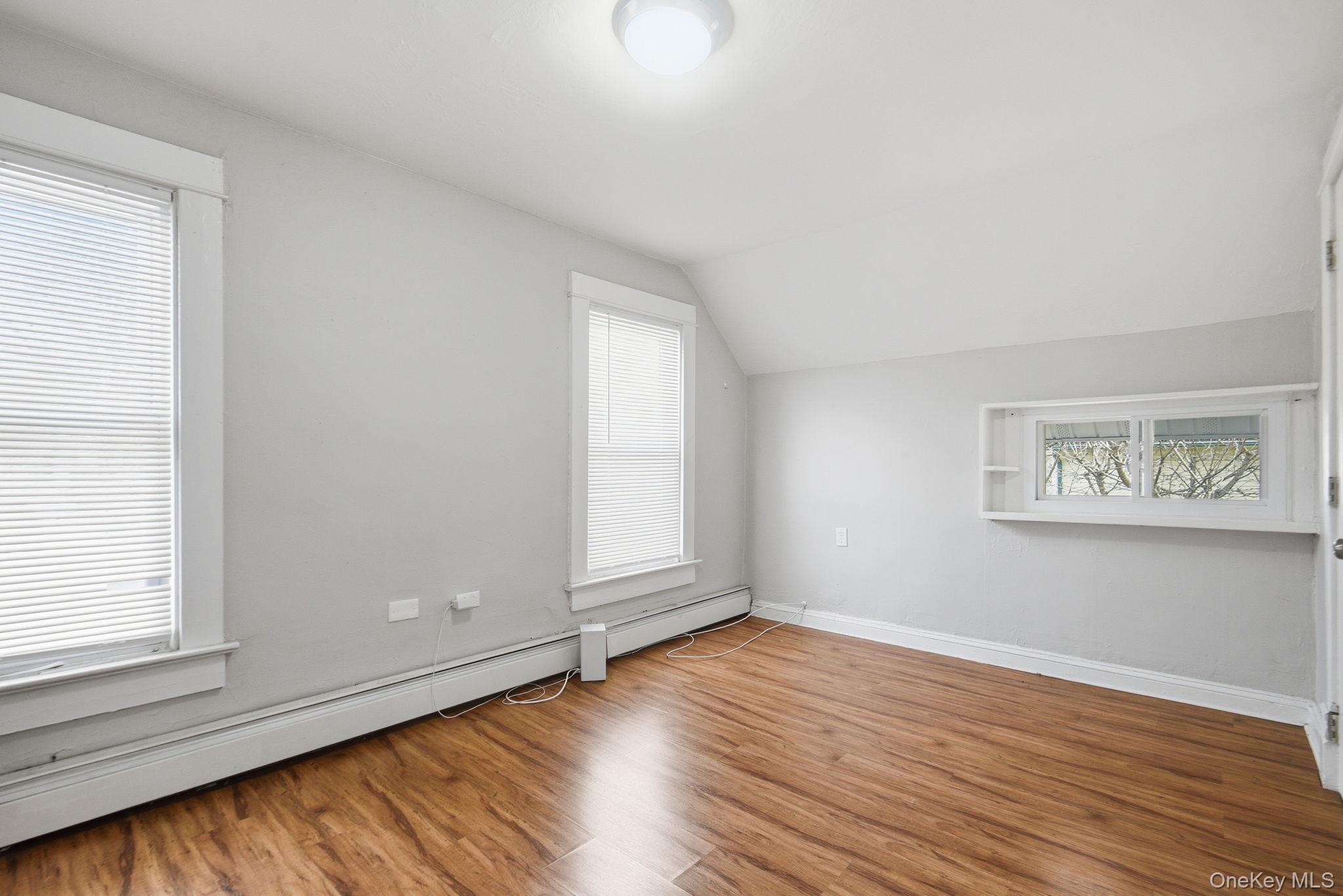 97 Maple Street Newburgh, NY 12550 - Photo 18 of 31 Bonus room with baseboard heating, wood finished floors, and vaulted ceiling