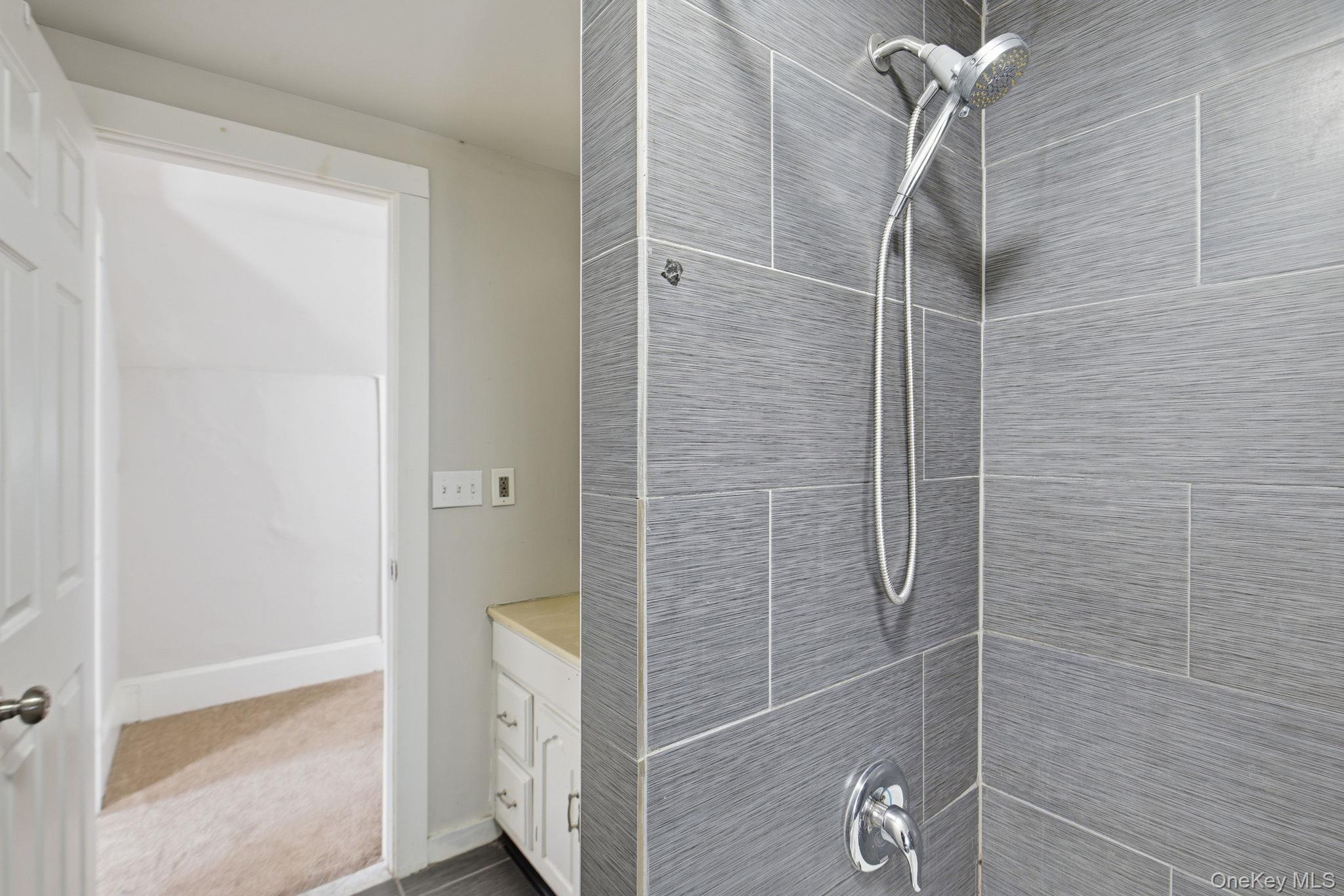 97 Maple Street Newburgh, NY 12550 - Photo 26 of 31 Bathroom with vanity, a tile shower, and carpet