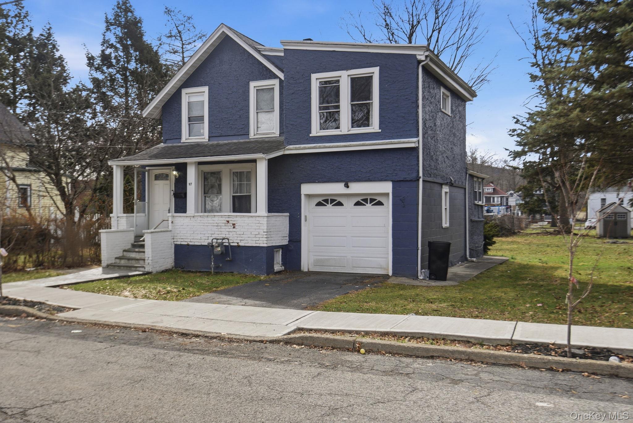 97 Maple Street Newburgh, NY 12550 - Photo 3 of 31 View of front of house with covered porch, a front lawn, brick siding, and driveway