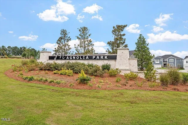a view of multiple houses with yard and parking