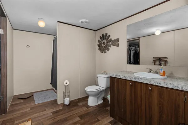 a bathroom with a granite countertop toilet sink and mirror
