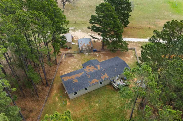 a view of a lake in front of house with trees all around