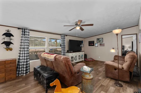 a living room with furniture a flat screen tv and a large window