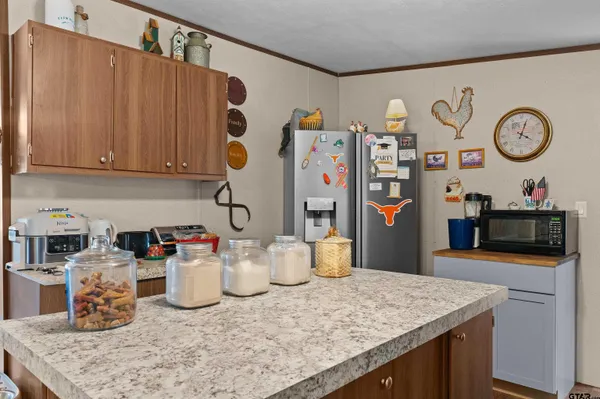 a kitchen with a refrigerator and a wooden cabinets