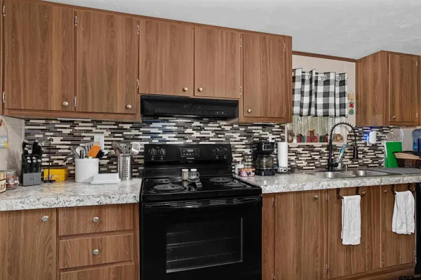 a kitchen with granite countertop stainless steel appliances a stove a sink and a microwave