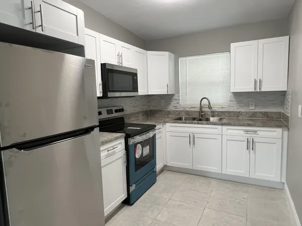 a kitchen with stainless steel appliances granite countertop a refrigerator stove a sink and dishwasher