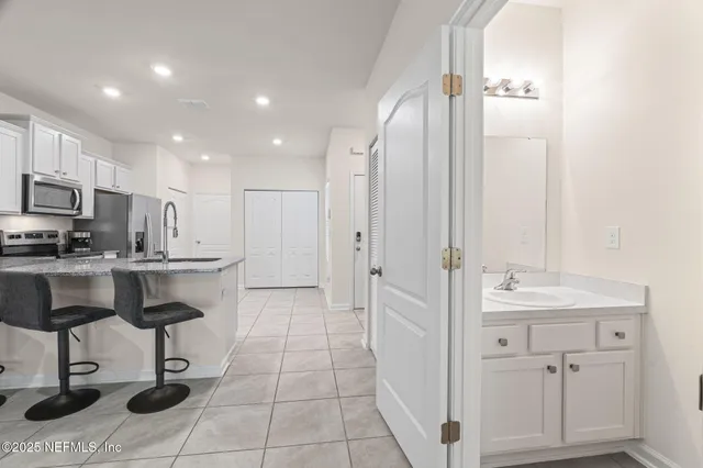 a kitchen with kitchen island granite countertop a sink and cabinets
