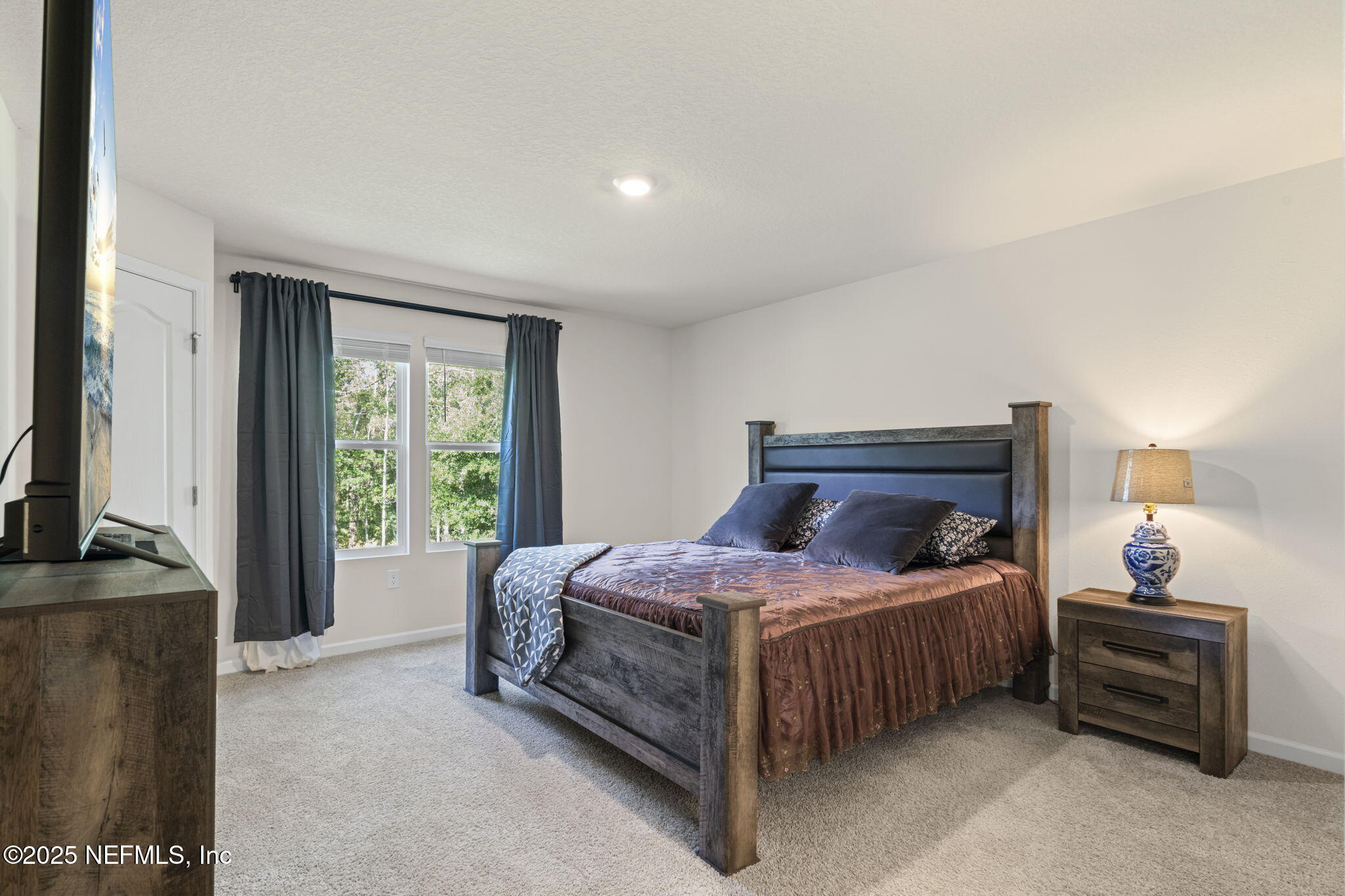 263 Talulla Trail St. Augustine, FL 32095 - Photo 13 of 32 a bedroom with a bed table and a flat tv screen