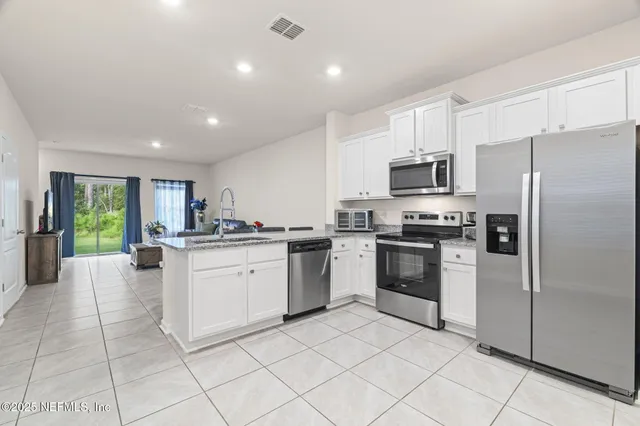 a kitchen with cabinets and stainless steel appliances