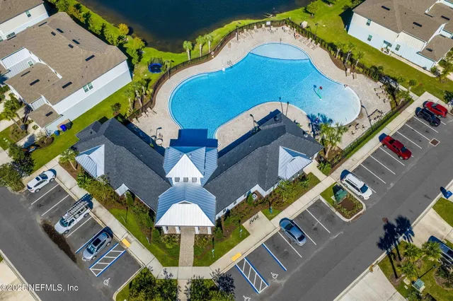 an aerial view of a house with swimming pool and outdoor seating
