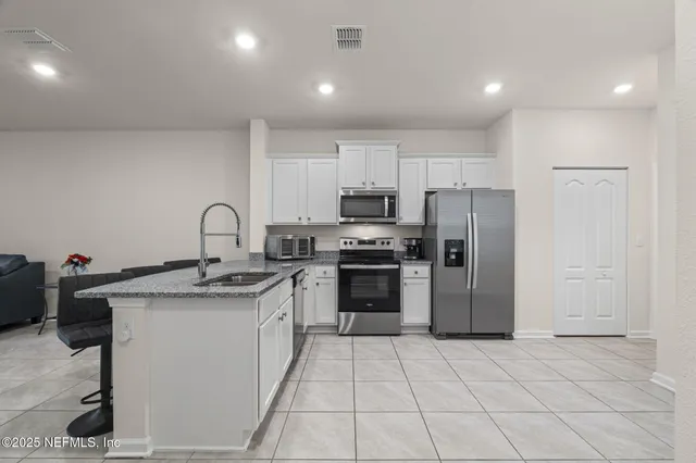 a kitchen with a sink a refrigerator and cabinets