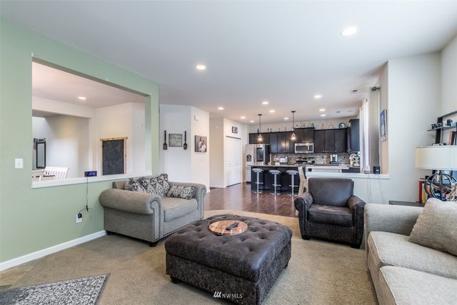 a living room with furniture and a view of kitchen