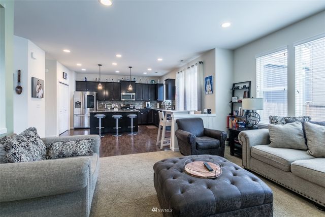 a living room with furniture and a view of kitchen