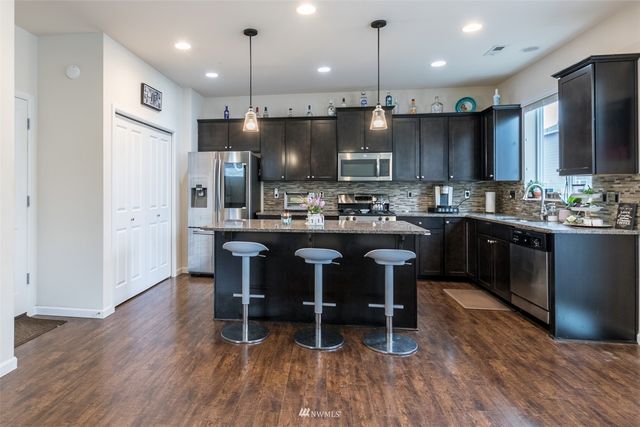 a kitchen with a sink a refrigerator and chairs