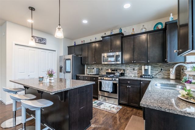 a kitchen with granite countertop a sink counter top space appliances and cabinets