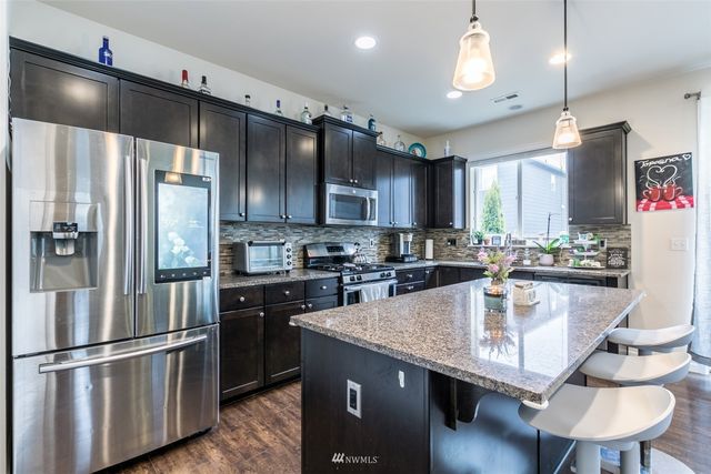 a kitchen with kitchen island a sink appliances and cabinets