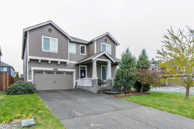 a view of a white house with a yard and plants